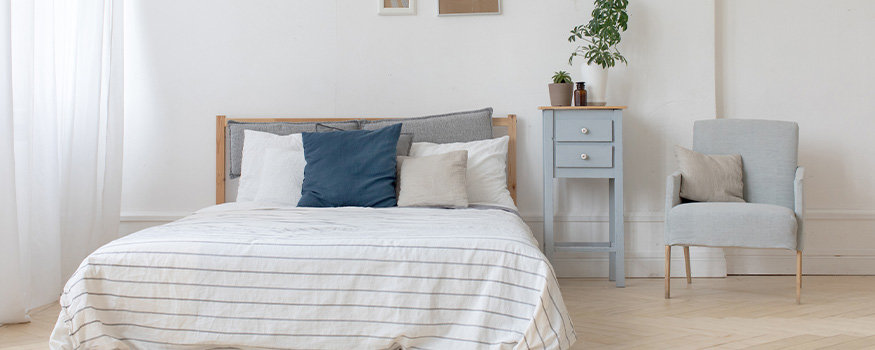 bed with white linens and blue and white pillows